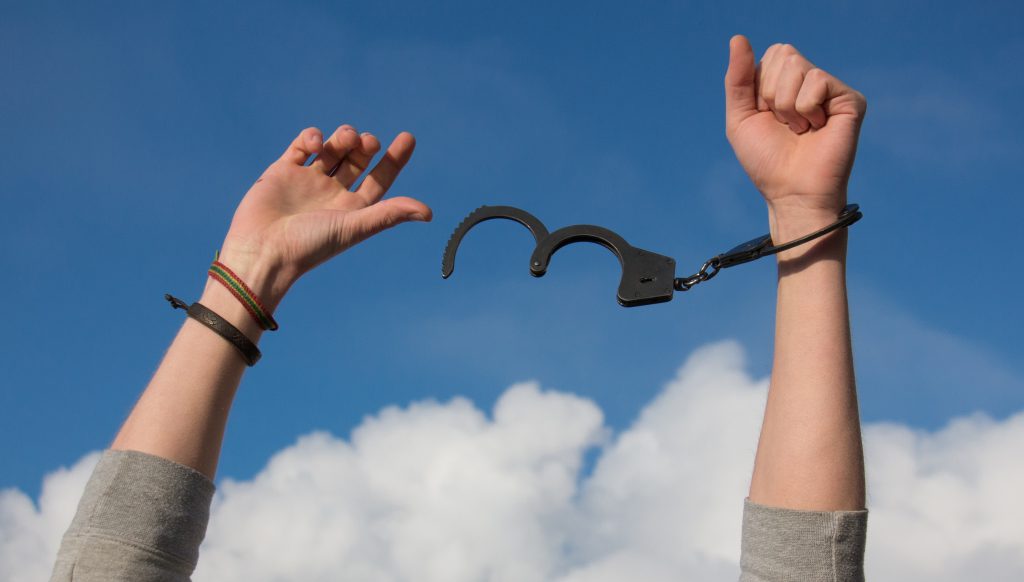 A person breaking out of handcuffs.